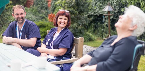 Two Southport & Formby Health staff laughing with a care home resident